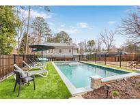 Backyard pool with lounge chairs and manicured landscaping offers a relaxing outdoor retreat at 2922 Parkridge Ne Dr, Brookhaven, GA 30319