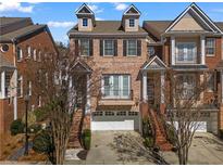 Beautiful brick townhome featuring a two-car garage and charming architectural details and balcony at 1029 Emory Parc Pl, Decatur, GA 30033