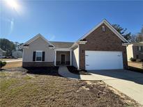 Charming single-story home featuring a brick accent, attached two-car garage, and manicured landscaping at 8620 Blair Ct, Douglasville, GA 30134