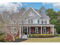 Charming two-story home with a welcoming front porch and a well-maintained landscaped yard at 2064 Democracy Dr, Buford, GA 30519