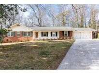 Charming brick home with a well-manicured lawn and attached two car garage at 7278 Selkirk Dr, Atlanta, GA 30328