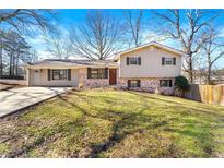 Split-level home featuring a brick and siding facade with a well-maintained front lawn at 3385 Lyndale St, Douglasville, GA 30135