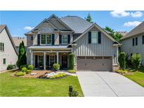 Charming two-story home with a brick and siding exterior, well-manicured lawn, and a two-car garage at 8220 Majors Ridge Way, Cumming, GA 30041