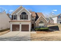 Charming two-story home featuring a two-car garage, stone accents and well-manicured landscaping at 6951 Foxmoor Way, Douglasville, GA 30134