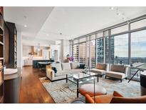 Spacious living room with hardwood floors, city views, and modern furnishings at 1065 Peachtree Ne St # 3005, Atlanta, GA 30309