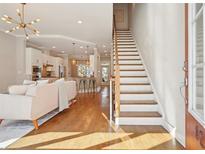 Inviting living room featuring hardwood floors, modern lighting, and an open layout leading to the kitchen at 1199 Huff Nw Rd # 127, Atlanta, GA 30318