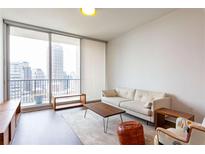 Bright living room with a comfortable sofa and a large window offering a stunning city view at 1080 Peachtree St # 2116, Atlanta, GA 30309