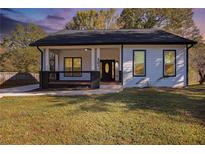 Charming one-story home showcasing a welcoming front porch and manicured lawn at 501 Harris Ave, Palmetto, GA 30268