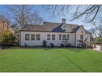 Charming home featuring a lush green lawn and neatly manicured landscaping at 1630 Sylvan Sw Rd, Atlanta, GA 30310