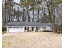 Charming single-story home with an attached two-car garage and a well-maintained front yard at 566 Sugar Valley Lane, Conyers, GA 30094
