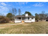 Charming home featuring a welcoming front porch and well-maintained lawn in a tranquil neighborhood at 203 Wynbrook Dr, Mcdonough, GA 30253