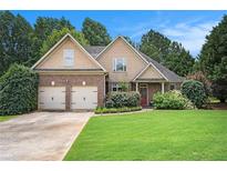 Charming two-story home features a manicured lawn and an attached two-car garage at 8000 Abington Dr, Locust Grove, GA 30248