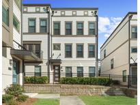 A charming three-story townhome featuring a well-kept lawn and a classic exterior design at 2028 Holtz Ln, Atlanta, GA 30318