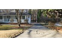 View of the front of the home with a driveway that needs some repair work to the concrete at 3875 Wintergreen Ct, Marietta, GA 30062