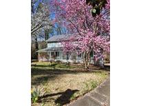 Charming two-story home with a covered porch surrounded by beautiful trees in full bloom at 3875 Wintergreen Ct, Marietta, GA 30062