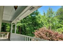 Covered porch view with white railings and lush greenery at 3875 Wintergreen Ct, Marietta, GA 30062