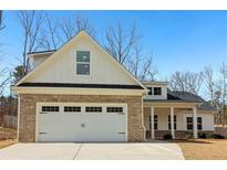 Charming home with a brick facade on the garage and white siding under a blue sky at 814 Harmony Rd, Temple, GA 30179