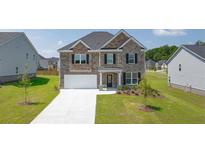 Beautiful two-story home with brick and siding exterior and well-maintained lawn at 1059 Blue Juniper Cir, Loganville, GA 30052