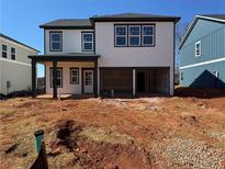 New two-story home featuring light siding, black trim, a covered patio, and an unfinished yard at 2108 Boxwood Circle Se, Conyers, GA 30094