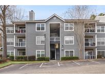 Attractive three-story condo building with balconies, gray siding and well maintained landscape at 3103 Santa Fe Pkwy, Atlanta, GA 30350