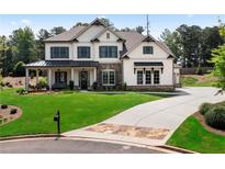 Charming two-story home with a manicured lawn, stone accents, and covered front porch at 805 Dempsey Ct, Marietta, GA 30064