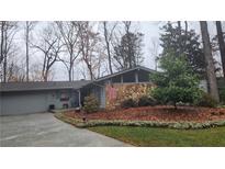 Charming single story home featuring a stone facade, garage, front lawn and attractive landscaping at 175 Old Farm Rd, Marietta, GA 30068