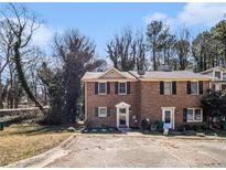 Charming brick townhome with a well-maintained lawn and mature trees at 5293 Oakridge Dr, Stone Mountain, GA 30083