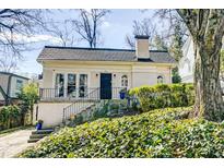 Charming brick home featuring an arched front door, landscaped yard, and classic architectural details at 231 Peachtree Ne Way, Atlanta, GA 30305
