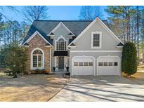 Charming two-story home with brick and stucco facade, two-car garage, and well-maintained landscaping at 206 Rattler Ct, Woodstock, GA 30189