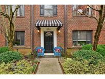 Charming brick condo with a striped awning, front door and blue chairs with red pillows at 694 Argonne Ne Ave # 4, Atlanta, GA 30308