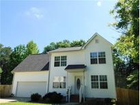 Charming two-story home featuring a well-maintained yard, attached garage, and bright white siding at 554 Samaritan Dr, Cumming, GA 30040
