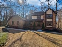 Charming brick home with a well-manicured lawn and mature trees creating a peaceful and inviting curb appeal at 2375 Muirfield Way, Duluth, GA 30096
