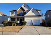 Charming two-story home with stone accents, a two-car garage and a well-manicured lawn at 7402 Gossamer St, Union City, GA 30291