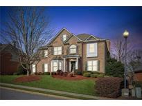 Charming brick two-story home with manicured lawn, mature trees and professional landscaping at 3690 Millwater Xing, Dacula, GA 30019