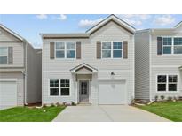 Charming two-story home with light siding, neutral shutters and attached one-car garage at 150 Chandler Trace, Covington, GA 30016