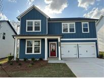Two-story blue home featuring a red door, white trim, two-car garage and well-maintained lawn at , Conyers, GA 30094