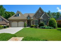 Charming brick and stone home with manicured lawn, two-car garage, and inviting curb appeal at 4880 Cecilia Sq, Cumming, GA 30040