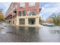 Brick condo building with covered entry and parking on a rainy day at 319 Atlanta Se St # 110, Marietta, GA 30060