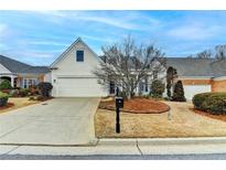 Charming home featuring a two-car garage and inviting curb appeal with a manicured lawn at 1635 Vinery Ave, Cumming, GA 30041