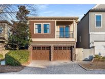 Two-story home boasts a two-car garage and a charming balcony overlooking a lush front yard at 322 Gray Shingle Ln, Woodstock, GA 30189