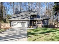 Charming home featuring a gray exterior, manicured lawn, two-car garage, and inviting front porch at 181 Arrowood Ln, Alpharetta, GA 30009