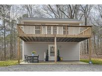 Charming home featuring an elevated deck, lower-level patio, and welcoming front door at 115 Bruce Rd, Douglasville, GA 30134