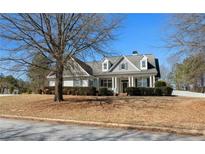 Charming home featuring a well-manicured lawn, classic architectural details, and a welcoming front porch at 155 Rose Creek Dr, Covington, GA 30014