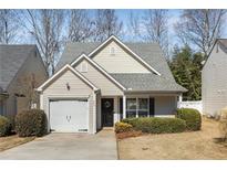 Charming single-story home with manicured landscaping and an attached garage, inviting curb appeal at 265 Woodland Way, Canton, GA 30114