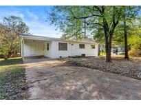 Charming single story home with covered carport and mature landscaping on a sunny day at 10152 Griffin Sw Ln, Covington, GA 30014