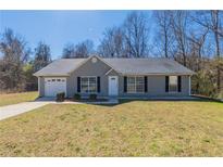 Charming single-story home featuring a well-manicured lawn and an attached single car garage at 11139 Silver Aspen Ct, Hampton, GA 30228