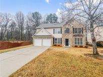 Charming two-story home boasts a two-car garage and manicured front lawn at 1156 Madison Green Sw Ln, Mableton, GA 30126