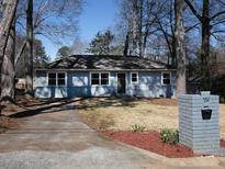 Charming single-story home with a blue-grey exterior, new windows, and a well-manicured front yard at 551 Floyd Se Dr, Smyrna, GA 30082