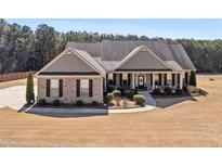 Charming single-story home featuring a manicured lawn, brick accents, and a welcoming front porch at 112 Standford Dr, Mcdonough, GA 30252