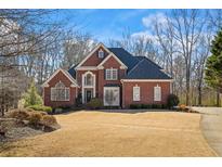 Beautiful brick home featuring a well-manicured lawn and professional landscaping at 7455 Richmond Way, Cumming, GA 30040